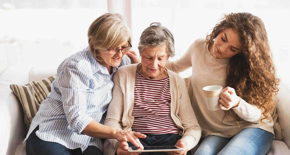 three people looking at an iPad