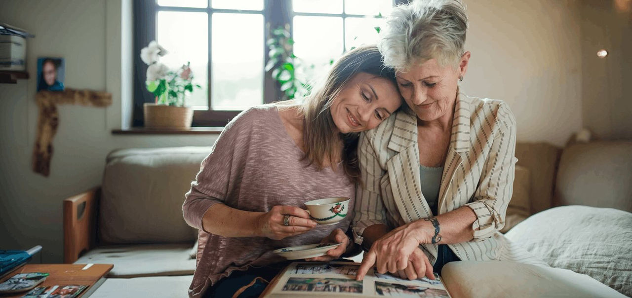 a woman with her grandmother looking at an album